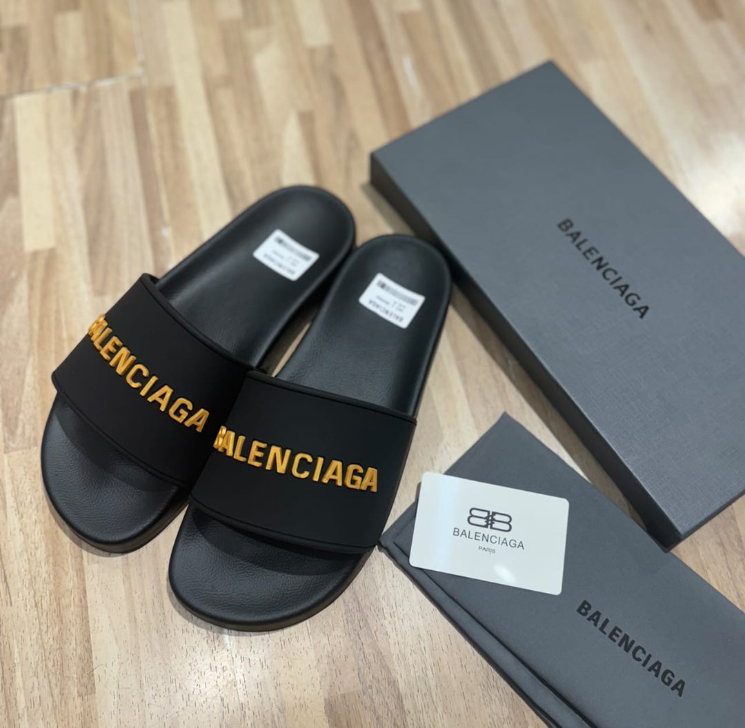 Flat slides in black rubber embossed with the Balenciga logo in gold - uaessss